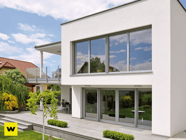 Modernes Einfamilienhaus mit großen Fenstern und Terrasse im gepflegten Garten.